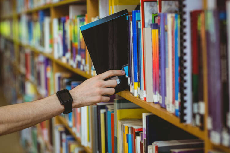 Student wearing a smart watch in library at the university